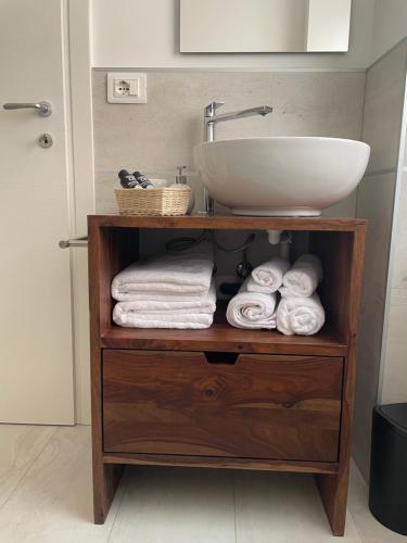uma casa de banho com um lavatório e uma prateleira com toalhas em Ai Tre Garofani B&B em Trento