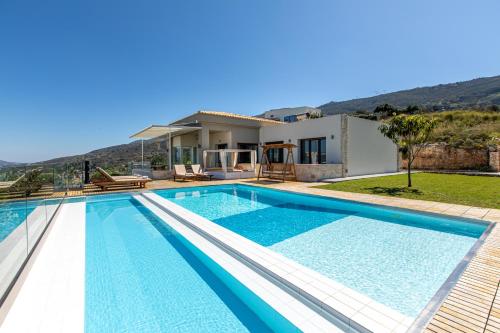 - une piscine en face d'une maison dans l'établissement Villa Kedria with a panoramic ocean view, à Souda