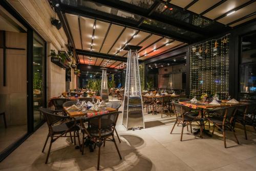 فندق اياس في عمّان: مطعم فيه طاولات وكراسي في الغرفة