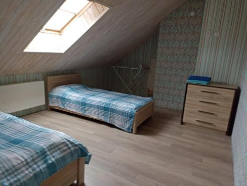 a attic bedroom with two beds and a skylight at Sweet Apartment in Truskavets