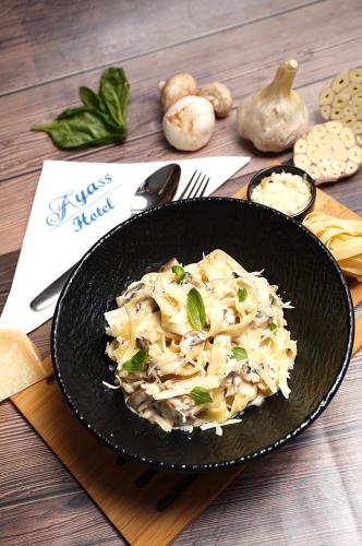 a pasta dish in a black bowl on a table at Ayass Hotel in Amman