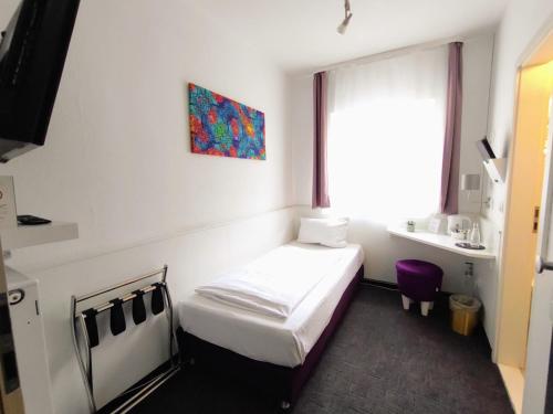 a small room with a bed and a sink at Les Nations in Berlin