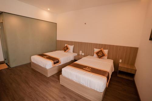 a hotel room with two beds and a mirror at LÊ ĐOÀN HOTEL in Rach Gia