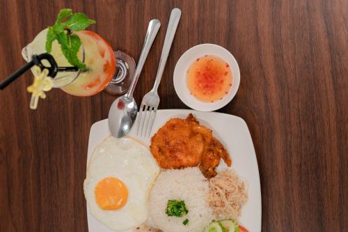 a plate of food with eggs and meat on a table at LÊ ĐOÀN HOTEL in Rach Gia