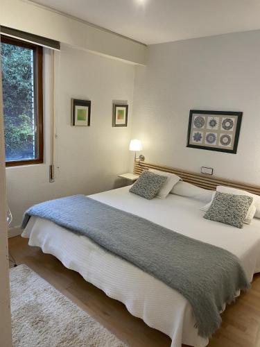 a bedroom with a large white bed with two pillows at Iturrain by smiling rentals in Hondarribia
