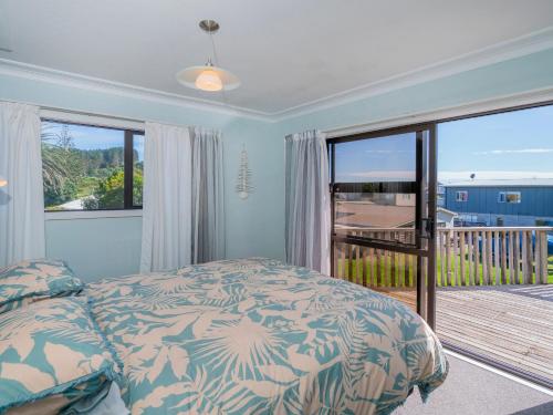 1 dormitorio con 1 cama y balcón en Opito Sea'scape - Opito Bay Holiday Home, en Opito Bay