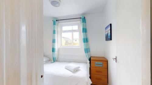 a small bedroom with a bed and a window at F62 Near Sea, Riviere Towans in Hayle