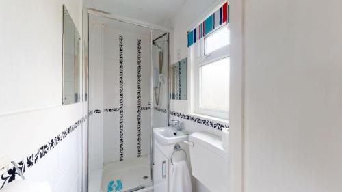 a white bathroom with a sink and a shower at F62 Near Sea, Riviere Towans in Hayle