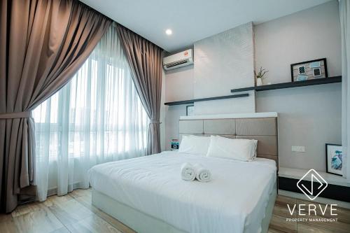 une chambre avec un lit avec deux serviettes blanches dessus dans l'établissement Ipoh Octagon Premium Suites by Verve, à Ipoh