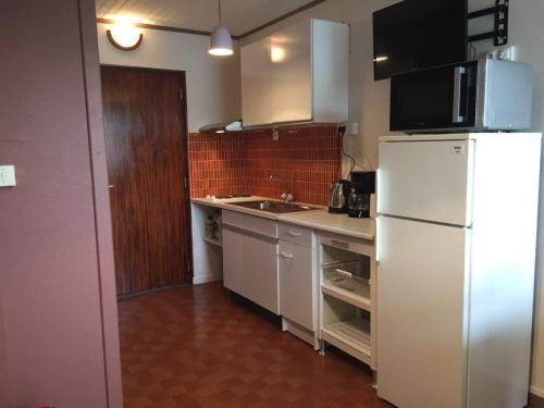 une cuisine avec un réfrigérateur blanc et un évier dans l'établissement Studio avec balcon et climatisation, à Balaruc-les-Bains