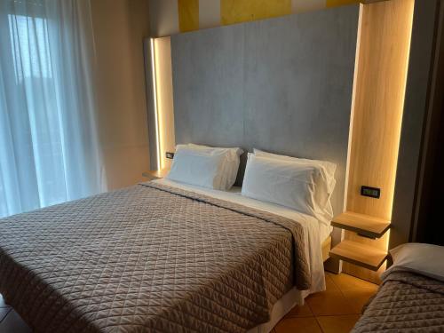 una camera da letto con un grande letto con due cuscini di Hotel Villa Rosa a Sirmione