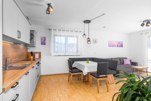 cocina y sala de estar con mesa y sofá en Ferienhäuser Buchenweg, en Bodenmais