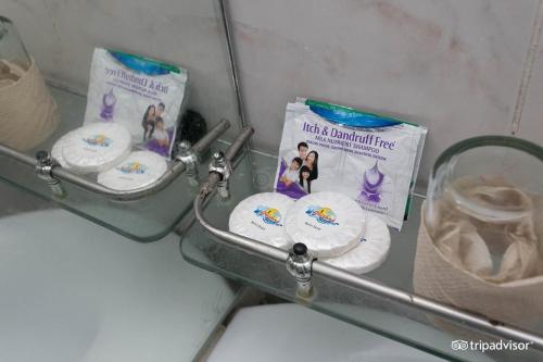 a bathroom with toilet paper and a rack with toiletries at Arizona Beach Resort, Subic Bay, Philippines 2200 in Olongapo