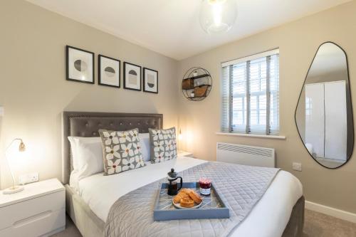 a bedroom with a bed with a tray of food on it at Elliot Oliver - 2 Bedroom Garden Apartment With Parking in Cheltenham