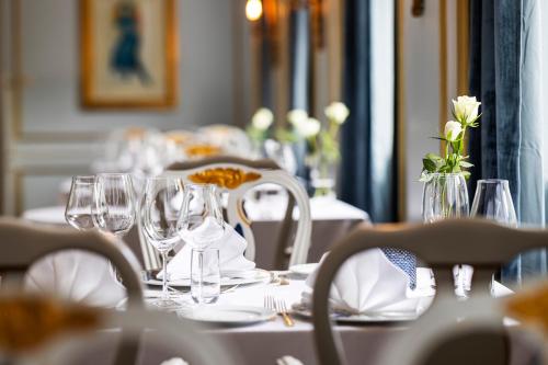 a table with glasses and plates and flowers on it at Hotel Refsnes Gods - by Classic Norway Hotels in Moss