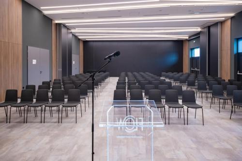 a conference room with black chairs and a microphone at Flow Hotel & Conference in Inárcs