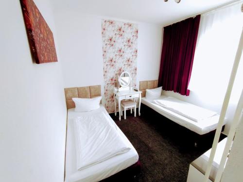 a room with two beds and a chair in it at Les Nations in Berlin
