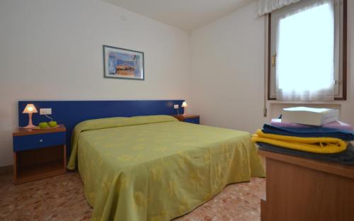 a bedroom with a green bed and a window at Appartamenti Cocai, Acquaverde in Bibione
