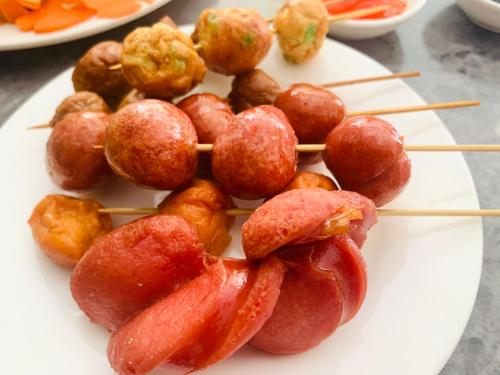 a plate of food with hot dogs on sticks at Villa Lake Shore Hoi An in An Bang