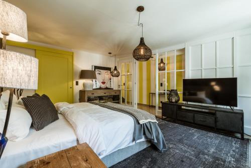 a bedroom with a large bed and a flat screen tv at Hotel / Weingut Meintzinger in Frickenhausen