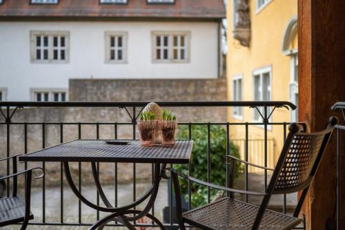 a small table and chairs on a balcony at Hotel / Weingut Meintzinger in Frickenhausen