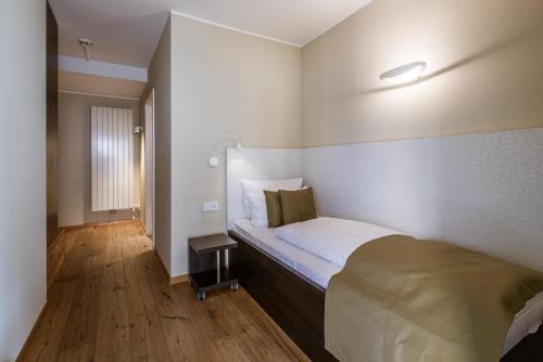 a bedroom with a large bed with a wooden floor at Hotel / Weingut Meintzinger in Frickenhausen