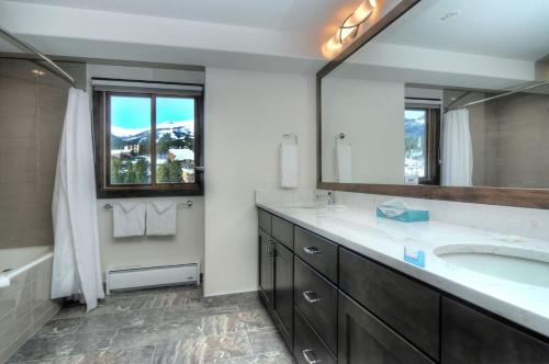 baño con lavabo y espejo grande en Mountain Elegant, en Breckenridge