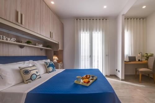a bedroom with a blue bed with a tray of food on it at POSTU D'INCANTU in Sciacca