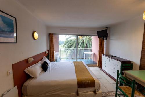 a hotel room with a bed and a balcony at Mer et Golf in Anglet