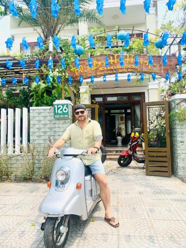 a man sitting on a scooter in front of a building at Villa Lake Shore Hoi An in An Bang
