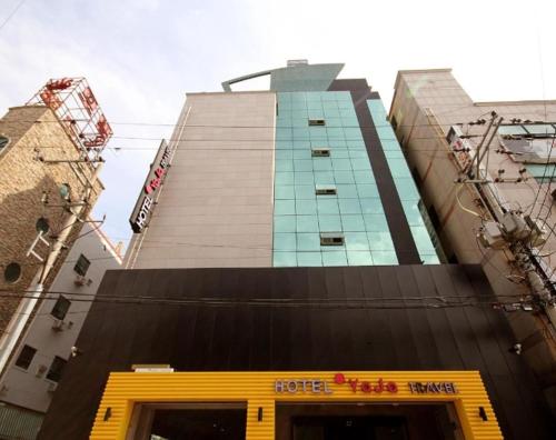 a hotel building with a yellow door in front of it at Hotel H2 in Ulsan