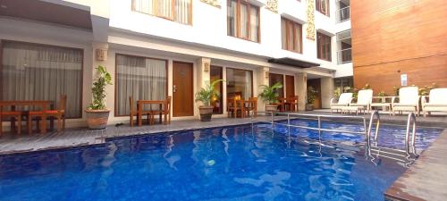 a hotel swimming pool in front of a building at The Sun Hotel & Spa Legian - CHSE Certified in Legian