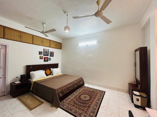 a bedroom with a bed and a ceiling fan at THE NOOK Nidana Suites in Guwahati