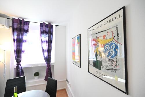 a dining room with two framed posters on the wall at Apartment Mia in Zadar