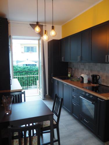 a kitchen with black cabinets and a table with chairs at Picena 177 in Chieti