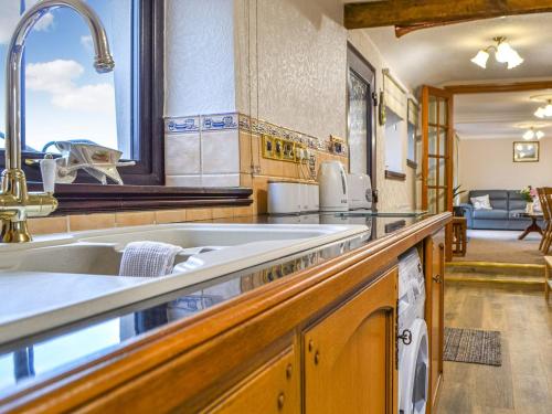 a kitchen with a sink and a counter top at Scalelands Cottage in Frizington