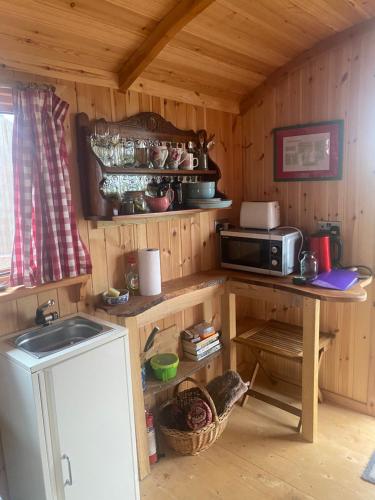 a kitchen with a table and a microwave at Granny’s Hut in Thornhill