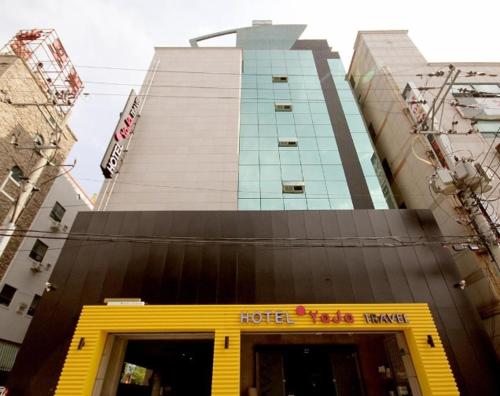 a hotel building with a yellow door in front of it at Hotel H2 in Ulsan