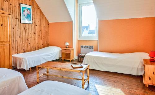 une chambre avec deux lits et une table dans l'établissement À 100m de la plage ! Maison pour 6 à Penmarch, à Penmarcʼh