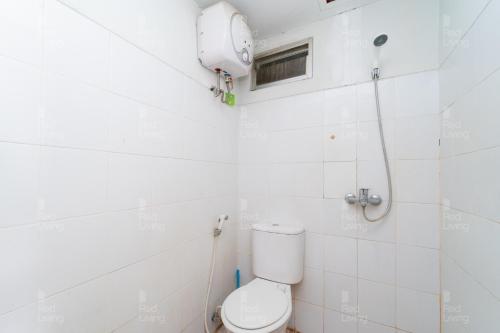 a white bathroom with a toilet and a window at RedLiving Apartemen The Suites Metro - Prisma in Bandung