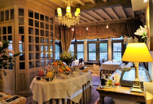 una sala da pranzo con tavoli e lampadario pendente di Relais Bourgondisch Cruyce, A Luxe Worldwide Hotel a Bruges
