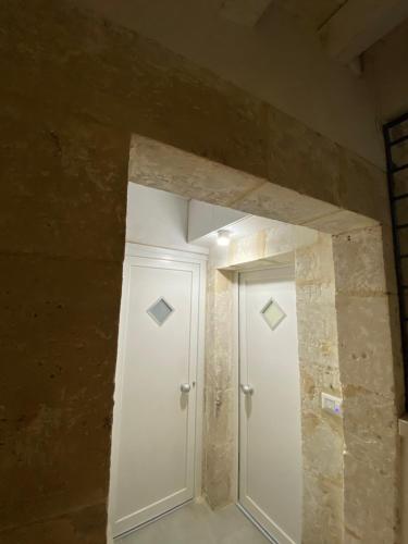 a room with a white door and a stone wall at Casa 68 Ortigia in Siracusa