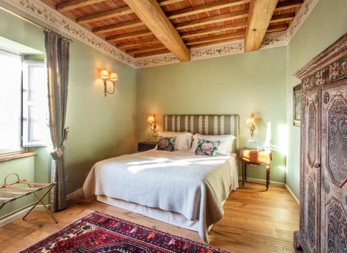 a bedroom with a bed and a wooden ceiling at Palazzo Tiglio - A Small Luxury Hotels of the World in San Pancrazio