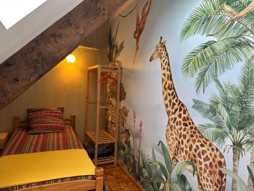 a bedroom with a giraffe mural on the wall at Gîte indépendant "Au merle chanteur" in Laramière