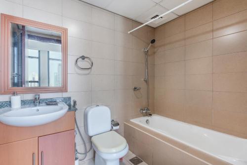 a bathroom with a sink and a toilet and a tub at Lakeside Residence - 2BR Apartment - Allsopp&Allsopp in Dubai