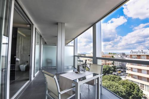 a balcony with a table and chairs and a large window at Waldorf Suite Hotel in Rimini