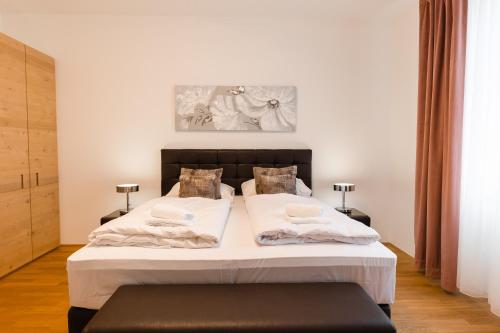 a bedroom with a large white bed with two pillows at Nadland Apartment Wehlistrasse in Vienna
