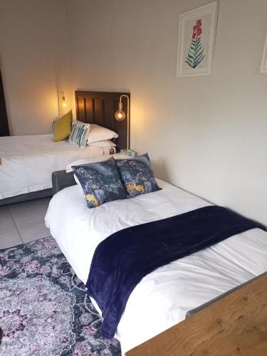 a bedroom with two beds and a rug at Dalau on Main in Paarl