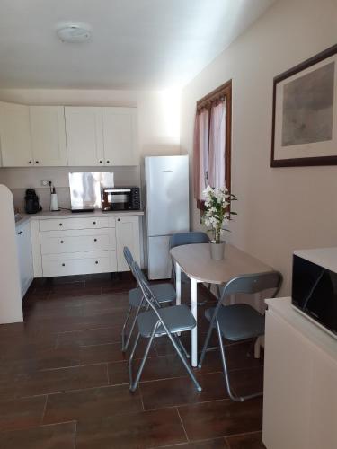 une cuisine avec une table, des chaises et un réfrigérateur dans l'établissement maison mitoyenne avec piscine Un moment chez Diane, à Grasse