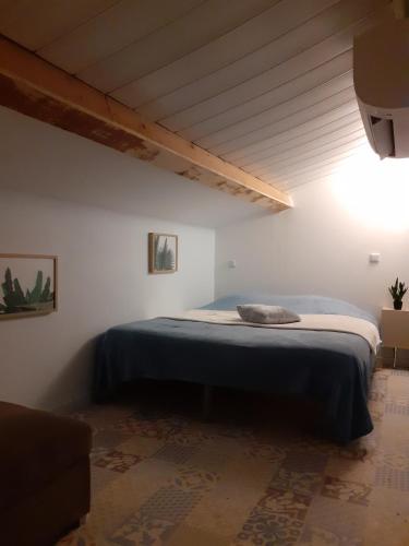 een slaapkamer met een bed in een witte kamer bij maison mitoyenne avec piscine Un moment chez Diane in Grasse